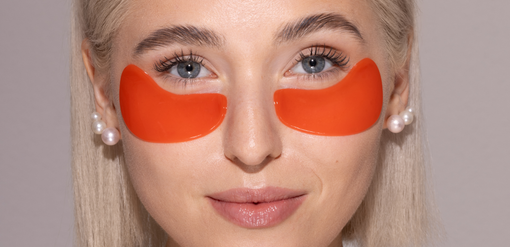 Rot-Orange Bakuchiol Augenpads unter den Augen einer blonden Frau