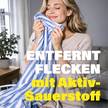 Frau riecht an blau weißem Kleidungsstück in Wohnung und Schrift