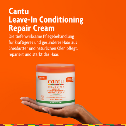Cantu Leave-in Repair Cream auf Hand und Schrift vor orangefarbenen Grund