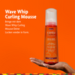 Cantu Wave Whip Curling Mousse - 248ml auf Hand, Schrift auf orangefarbenem Grund
