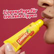 Frau die Carmex Cherry aufträgt und Schrift