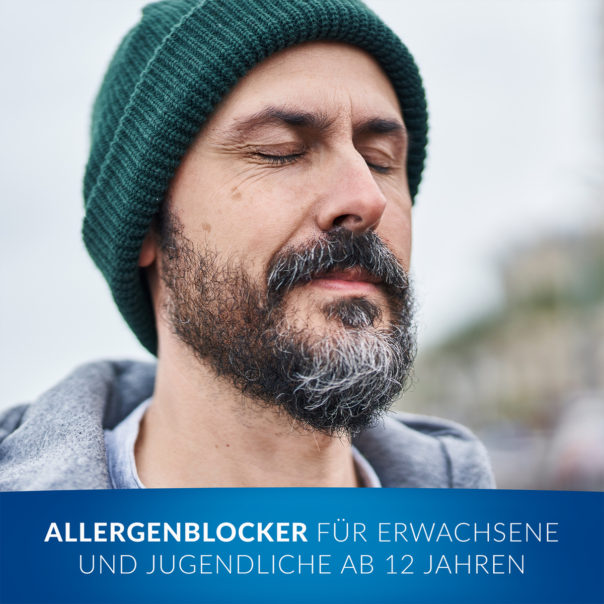 Durchatmender Mann mit Mütze, im Vordergrund Balken mit Schrift