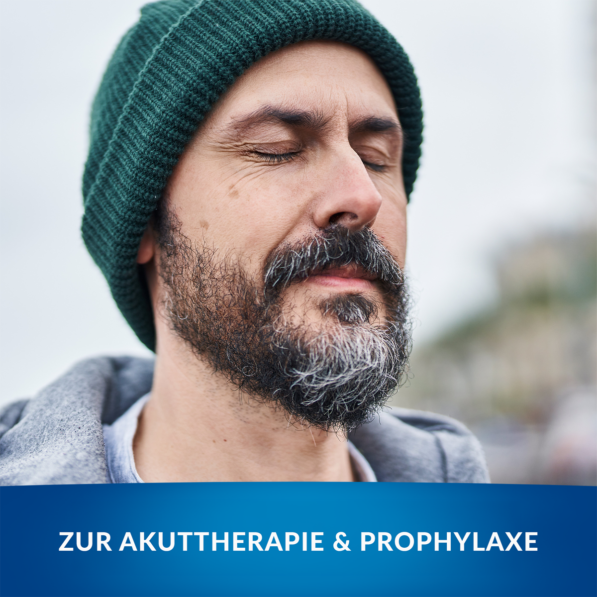 Durchatmender Mann mit Mütze in der Natur, im Vordergrund Balken mit Schrift