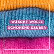 Nahaufnahme von gestrickter Wolle im Rahmen und Schrift auf pinken Balken