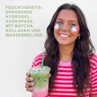 Frau mit Matchagetränk in der Hand und Schrift vor grauem Hintergrund