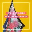 Seidentuch auf gelbem Grund und Schrift auf pinken Balken