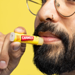 Mann der Carmex Classic aufträgt