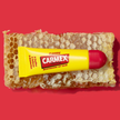 Carmex Classic Tube auf Honigwabe auf rotem Grund