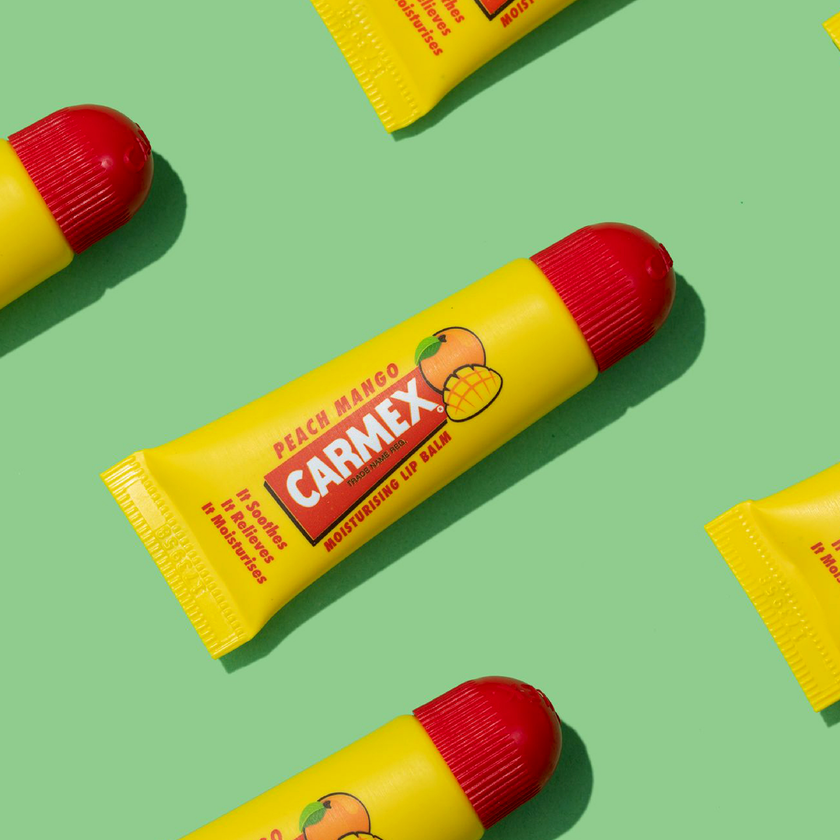 Carmex Peach Mango Tuben auf grünem Hintergrund
