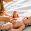 Frau cremt Baby Bäuchlein ein