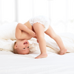 Baby kopfüber auf Bett