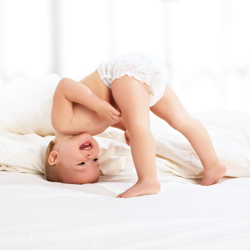 Baby kopfüber auf Bett