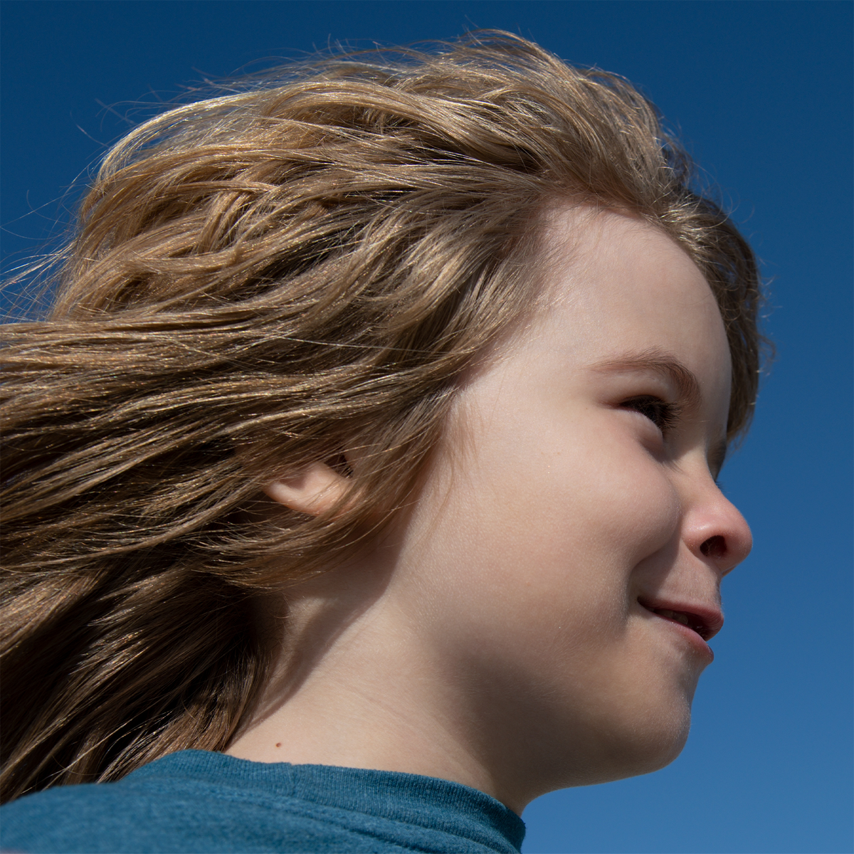 Kind im Profil vor Himmel