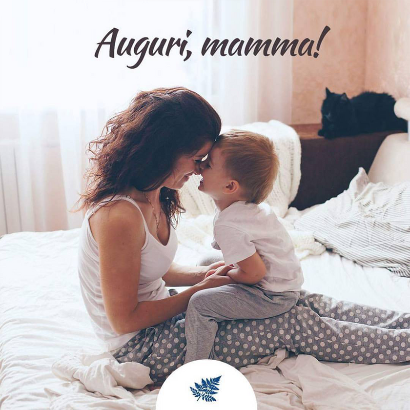 Mutter mit Kind auf dem Schoß im Bett sitzend