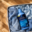 Felce Azzurra Weichspüler Moon Flower - 900ml auf Wäsche im Wäschekorb auf Pakett