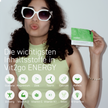 Frau mit Sonnebrille und Vit2go Energy Sachet in der Hand vor grauem Hintergrund, Schrift und Icons in weißen Kreisen im Vordergrund