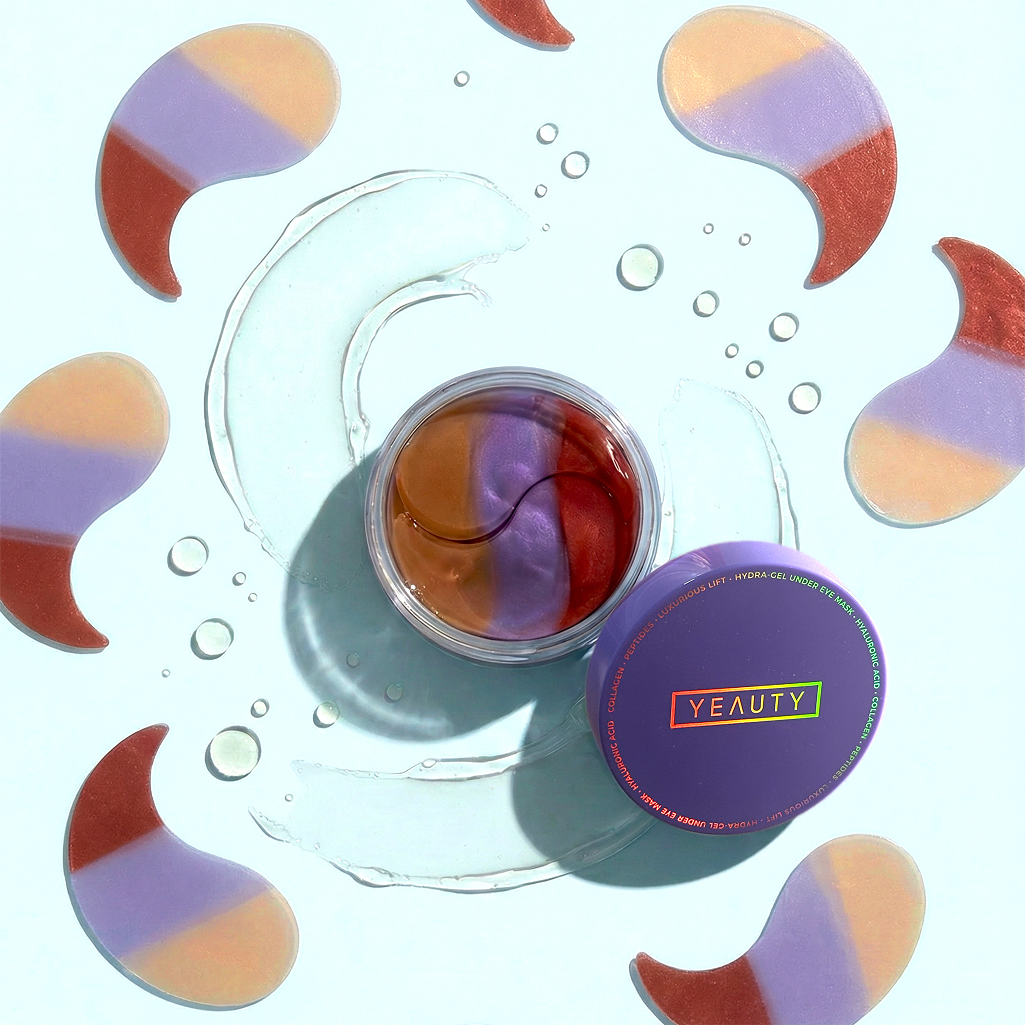 Geöffneter YEAUTY Luxurious Lift Eye Tripad Mask Tiegel auf blauem Grund umgeben von YEAUTY Luxurious Lift Eye Tripad Masks und Gel