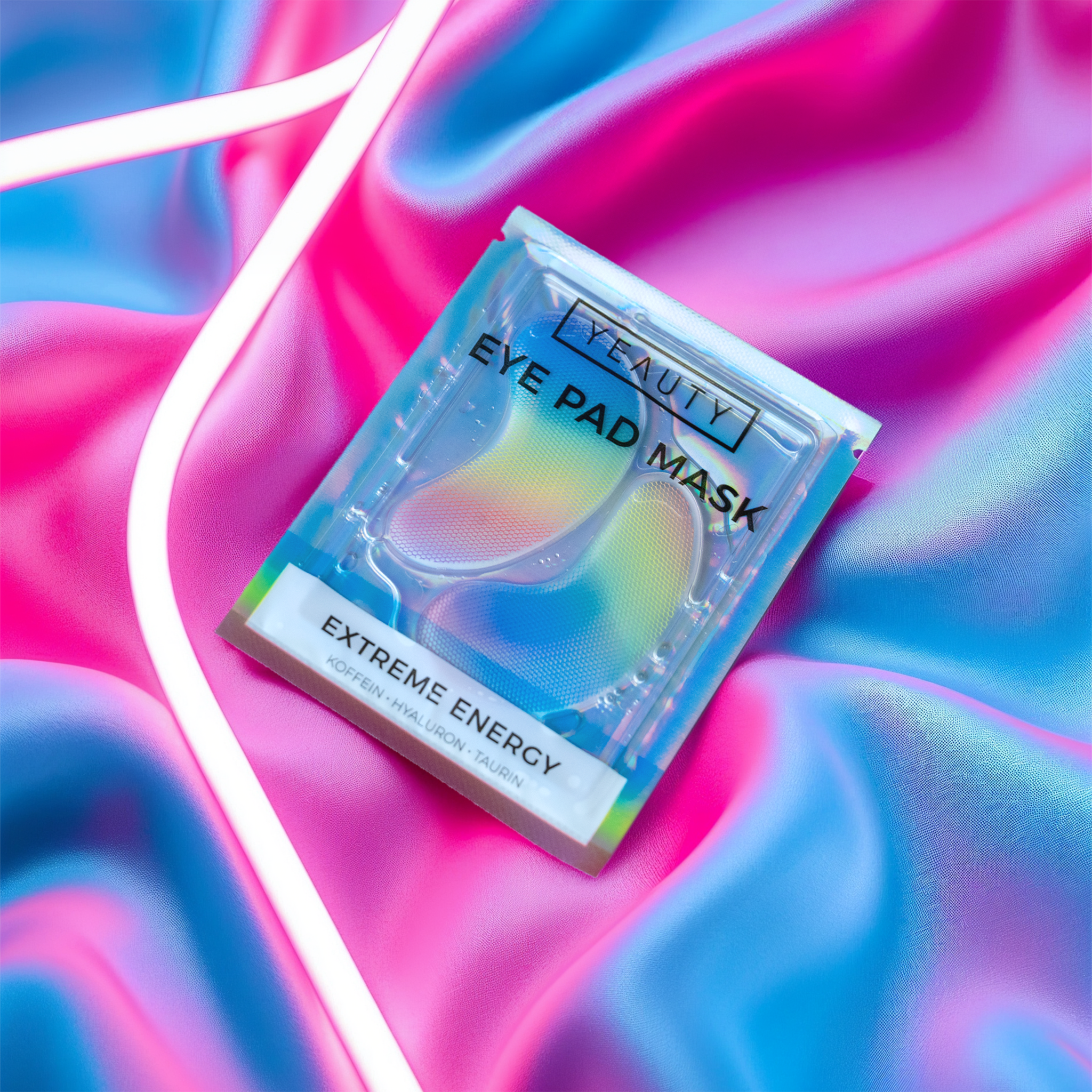 YEAUTY Eye Pad Mask Extreme Energy Verpackung auf Stoff und neben Neonlicht