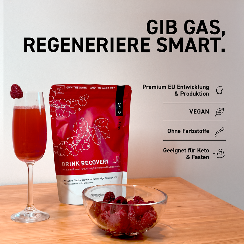 Vit2go Drink Recovery Standbodenbeutel, mit roter Flüssigkeit gefülltes Glas und Himbeere am Rand sowie Glasschale mit Himbeeren gefüllt auf Holztisch vor weißer Wand, Schrift und Icons im Vordergrund