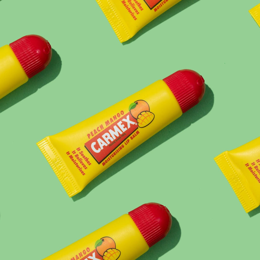Carmex Peach Mango Tuben auf grünem Hintergrund