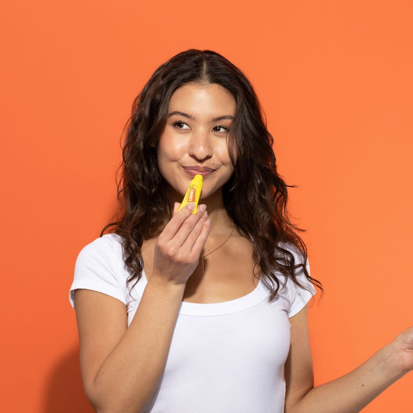 Frau benutzt Carmex Peach Mango Tube