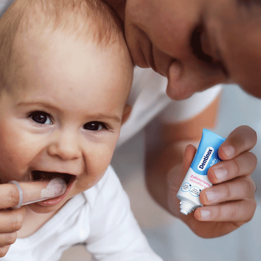 Baby bekommt von Mami die Zähne geputzt mit Dentinox Zahncreme Mundflora Baby